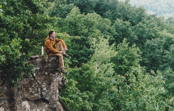 旅行者年轻人休息在峭壁之上和喝茶从热水瓶室外 — 图库照片