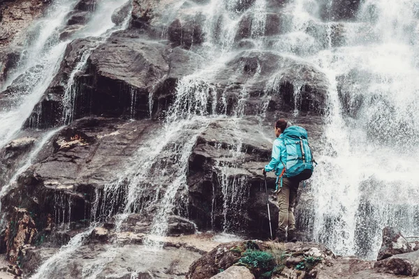 Backpacker Młoda Kobieta Przekraczania Góry Rzeka Kijki Trekkingowe Pobliżu Wodospadu — Zdjęcie stockowe