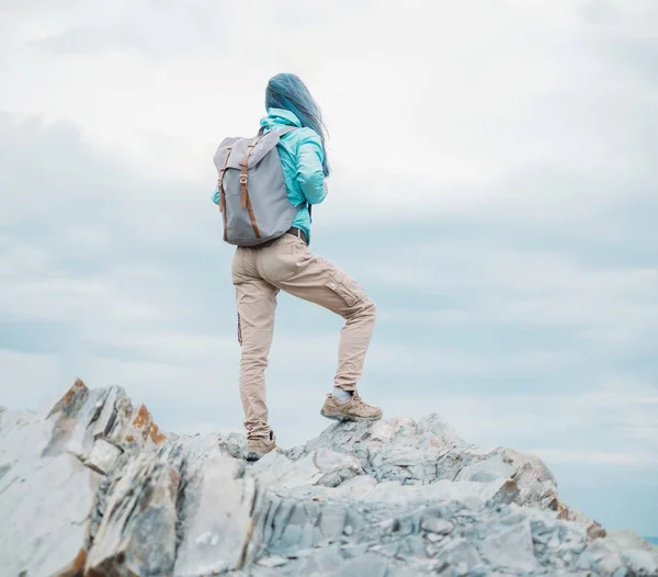 認識できないエクスプ ローラー バックパック ピークの崖の上に立って 遠くを見ていると若い女性 — ストック写真