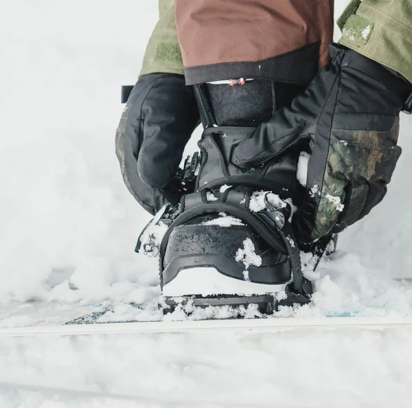 Man zetten snowboard, close-up — Stockfoto