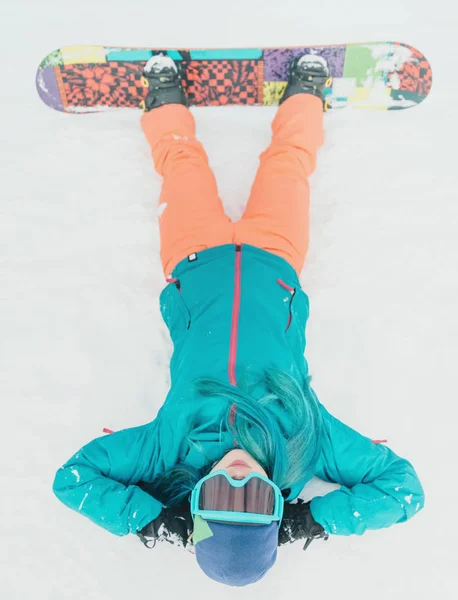 Mulher com snowboard deitado na neve — Fotografia de Stock