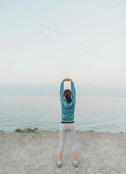 Entrenamiento de mujer joven en la costa —  Fotos de Stock