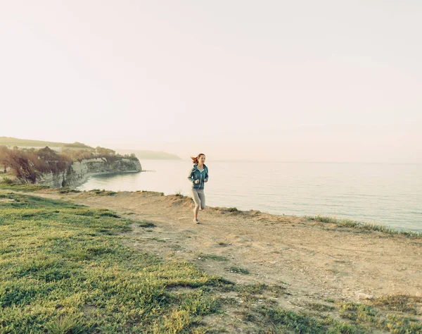 Mujer joven corriendo en la costa — Foto de Stock