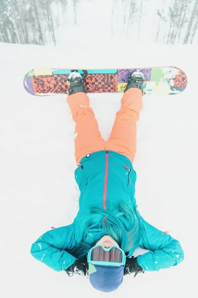 Snowboardista žena ležící na sněhu — Stock fotografie
