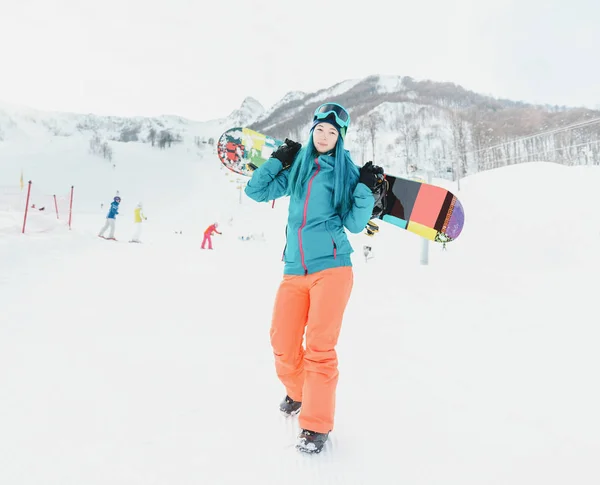 Kobieta z snowboard na ośrodek narciarski — Zdjęcie stockowe
