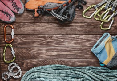 Climbing equipment on wooden background.  clipart