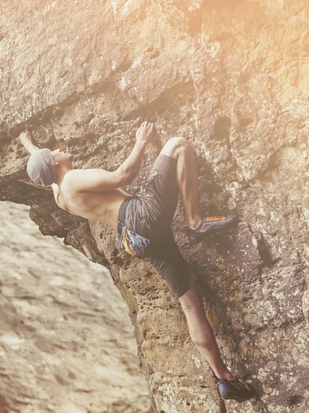 Homme grimpant sur le rocher par une journée ensoleillée . — Photo