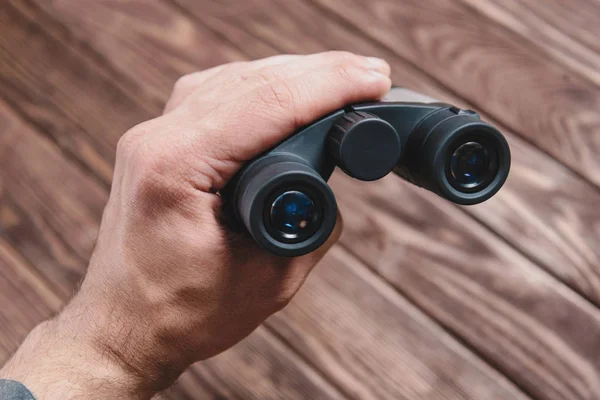 Hand Mit Fernglas Auf Holzgrund — Stockfoto