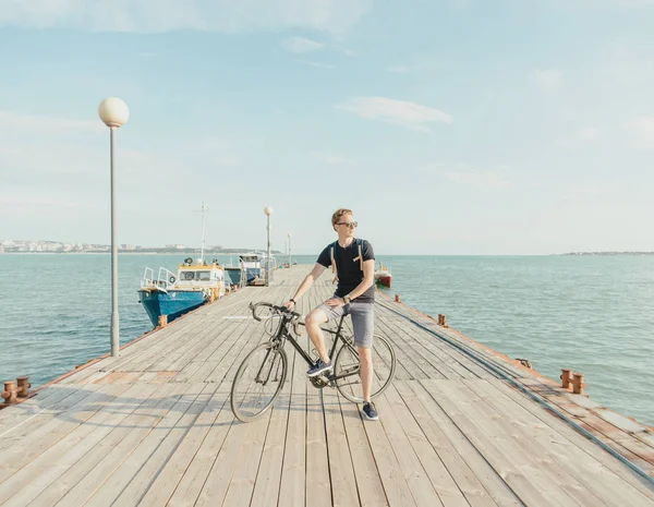 Mann steht mit Fahrrad auf Seebrücke. — Stockfoto