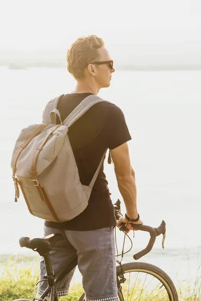 Man standing with bike outdoor. — Stock Photo, Image