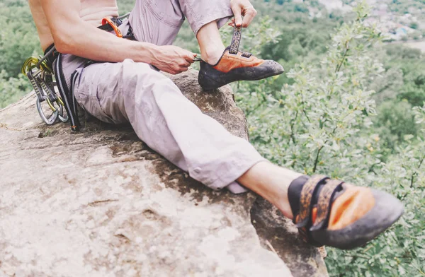 Hombre poniéndose zapatos de escalada al aire libre . — Foto de Stock