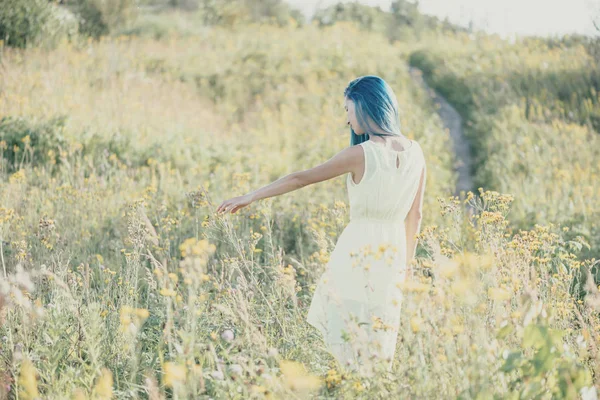 Femme marchant sur prairie de fleurs sauvages . — Photo