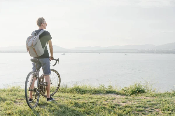 Tipo con bicicleta caminando por la costa . — Foto de Stock