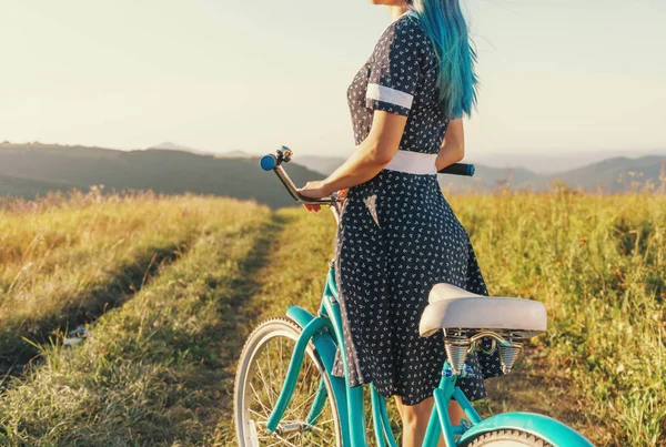 Женщина стоит с велосипедным крейсером на открытом воздухе . — стоковое фото