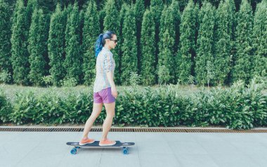 Güzel kız bir longboard açık sürme. 