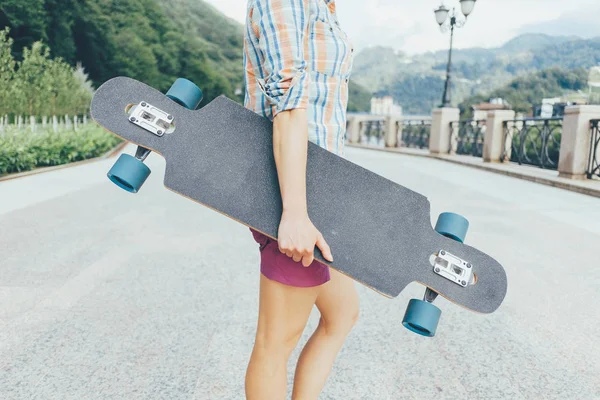 Adolescent méconnaissable avec longboard . — Photo