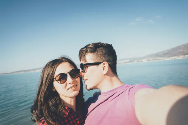 Loving couple taking selfie on background of sea — Stock Photo, Image