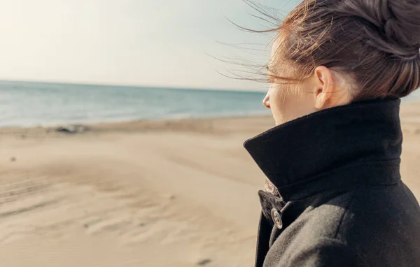 海岸を歩いてコートの女. — ストック写真