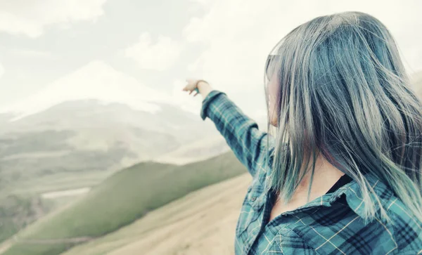 Mujer apuntando a la montaña con pico nevado . — Foto de Stock