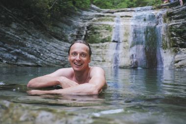 Mutlu adam şelale gölünde dinlenme. 