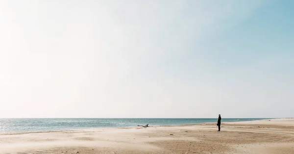 Mujer caminando por la costa arenosa . — Foto de Stock