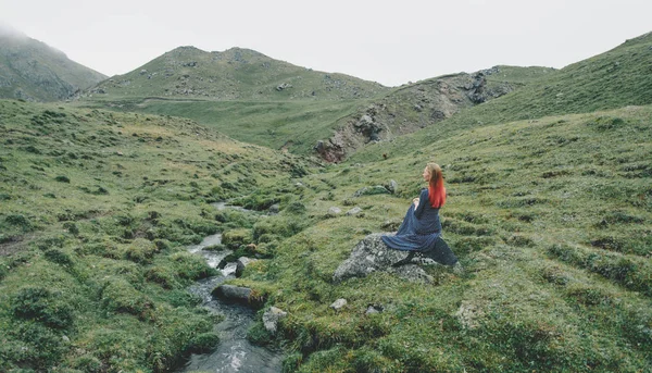 Beautiful woman sitting near the stream. — Stock Photo, Image