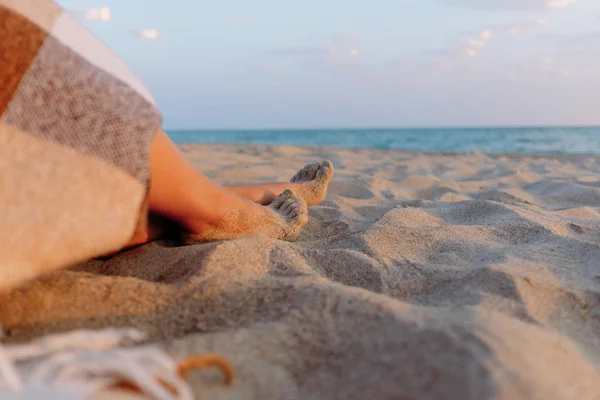 Frau ruht sich am Sandstrand aus, Blick auf Beine. — Stockfoto