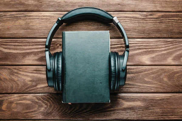 Headphones around a paper book. — Stock Photo, Image