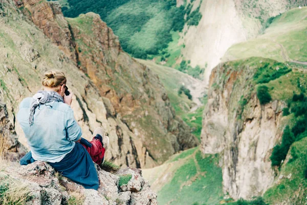 Photographer sitting high in the mountains. — Stock Photo, Image