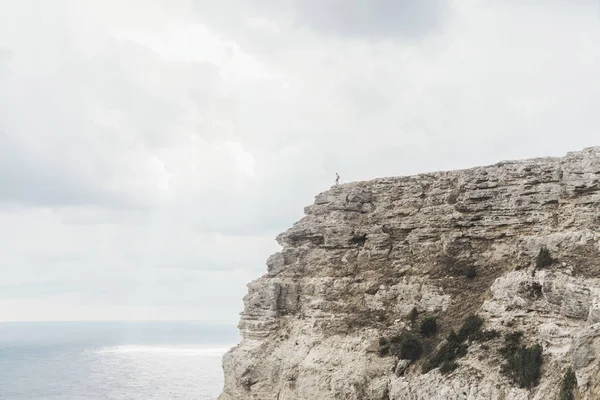 Piccola figura del viaggiatore in piedi sul bordo della scogliera . — Foto Stock