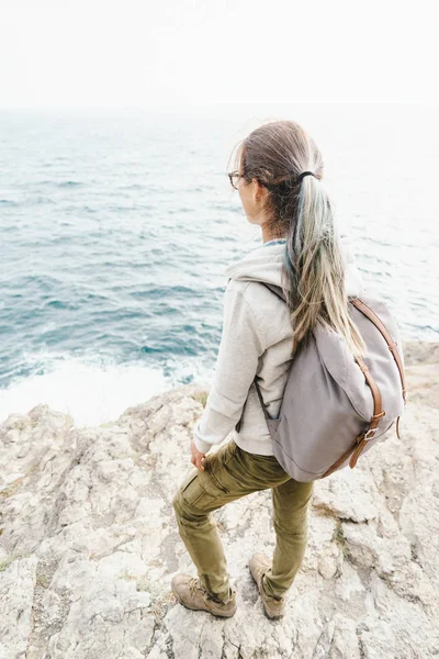 Backpacker dívka stojící na pobřeží Jaderského moře. — Stock fotografie