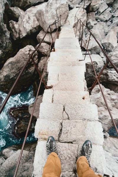 Hombre cruzando el río en una escalera de piedra . — Foto de Stock