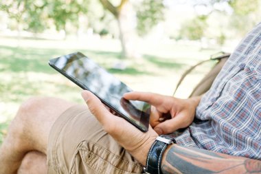 Parkta tablet ile erkek öğrenci. 