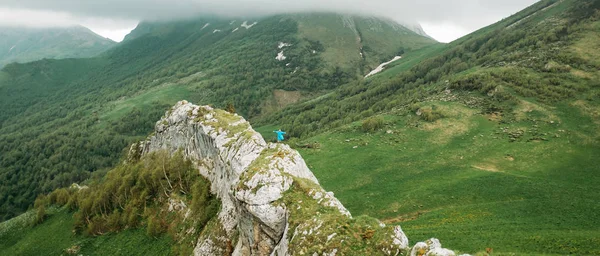 Female explorer standing with raised arms on cliff. — Stock Photo, Image