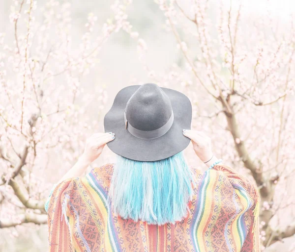 Mujer con pelo azul caminando en floreciente jardín de primavera . —  Fotos de Stock