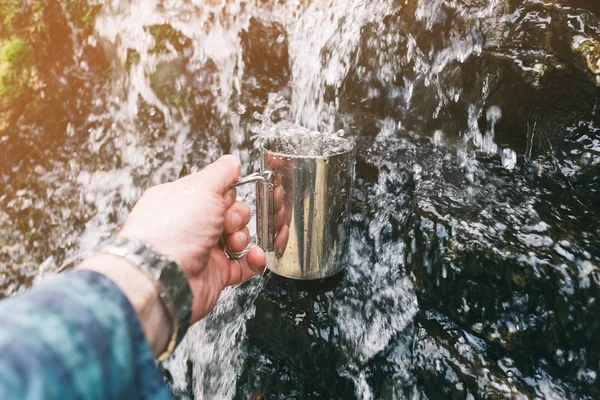 Hand gieten van water in beker buiten. — Stockfoto