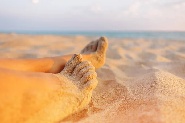 Close-up view of female barefoot legs on sand. — Stock Photo, Image