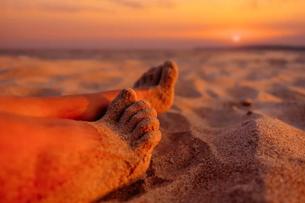 View of female barefoot legs on beach sand at sunset. — Stock Photo, Image