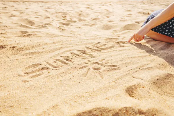 Frau zeichnet Wort Sommer in den Sand. — Stockfoto