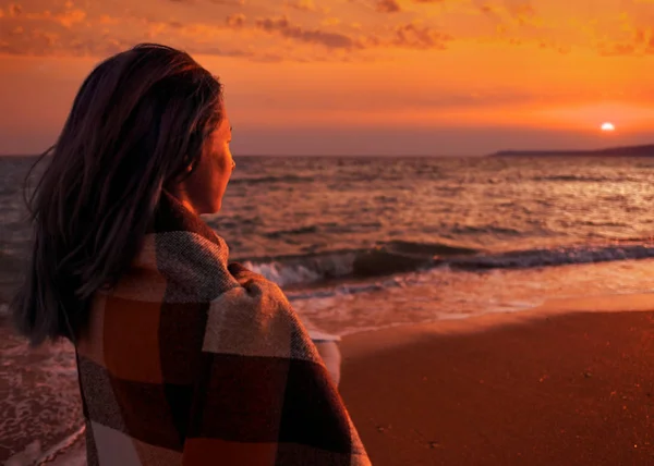 Žena se těší pohled na západ slunce na pláži. — Stock fotografie