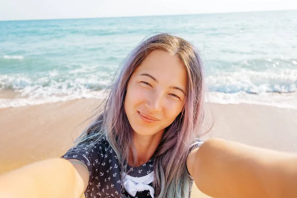 Lächelnde Frau macht Selfie am Strand. — Stockfoto