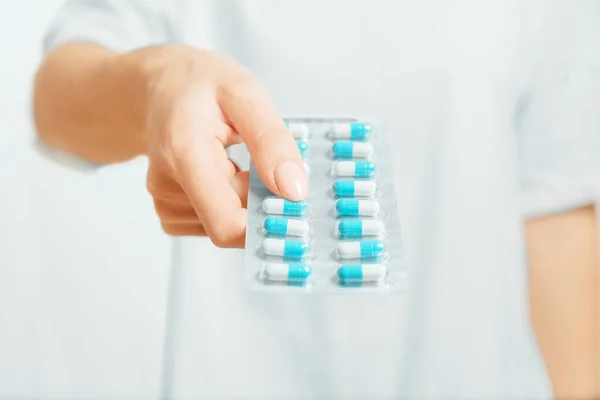 Unrecognizable woman holding a blister of medical capsules. — Stock Photo, Image