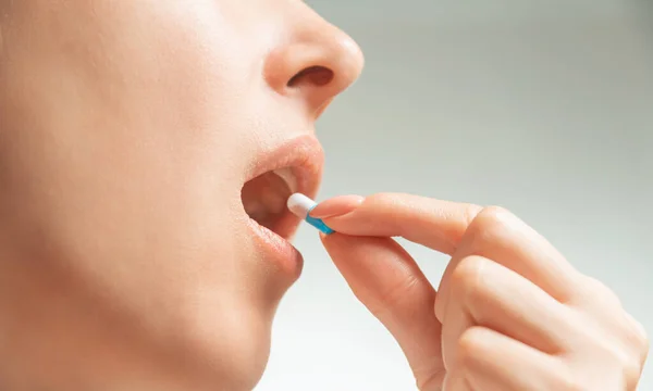 Mulher tomando uma cápsula médica ou vitamina . — Fotografia de Stock