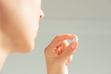 Elinde ilaç ya da vitamin olan bir kadın..