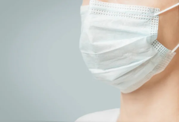 Unrecognizable woman in medical protective mask, close-up. — Stock Photo, Image