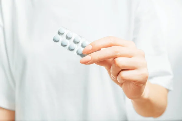 Female hand holding a blister of medical tablets. — Stock Photo, Image