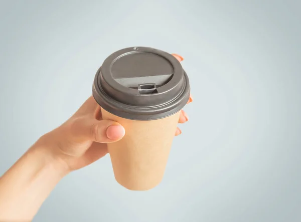 Female hand holding take away paper cup of coffee, pov. — Stock Photo, Image