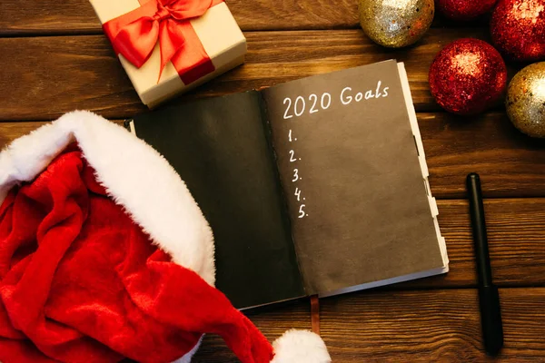 Goals planning 2020 in notebook near Christmas decorations. — Stock Photo, Image