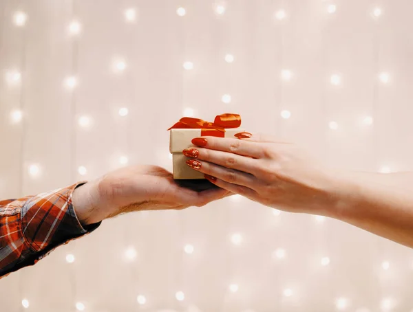 Man hand giving a gift box with red ribbon to woman. — Stock Photo, Image
