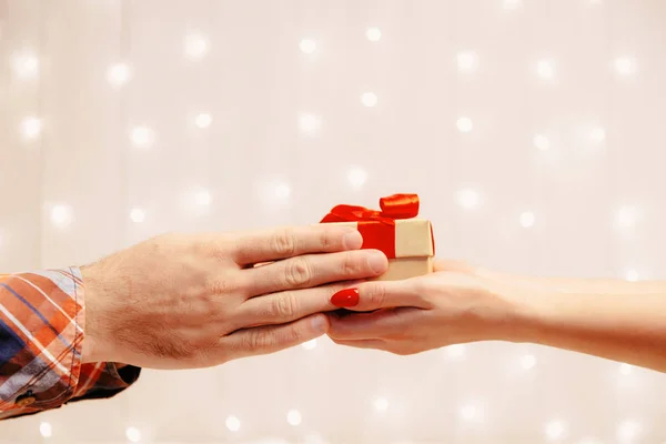 Mãos masculinas dando uma caixa de presente para a mulher . — Fotografia de Stock